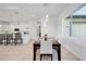 Bright dining area with modern light fixtures, adjacent kitchen, and large windows at 6146 Grandeur St, Englewood, FL 34224