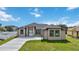 Charming single-story home featuring a well-manicured lawn and a paved driveway at 6146 Grandeur St, Englewood, FL 34224