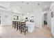Open-concept kitchen showcasing a center island with bar stools and modern white cabinetry and lighting at 6146 Grandeur St, Englewood, FL 34224