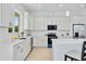 Modern kitchen featuring white cabinets, quartz countertops, and stainless steel appliances at 6146 Grandeur St, Englewood, FL 34224