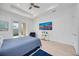 Spacious main bedroom with wood floors, ceiling fan, backyard access, and bright natural light from two windows at 6146 Grandeur St, Englewood, FL 34224
