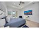 Spacious main bedroom with wood floors, ceiling fan, backyard access, and bright natural light from two windows at 6146 Grandeur St, Englewood, FL 34224