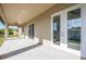 View of the covered outdoor patio featuring white doors and a ceiling fan at 6146 Grandeur St, Englewood, FL 34224