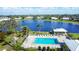 Aerial view showcases the community pool and nearby pond amidst lush greenery, providing a serene retreat at 6701 12Th W Ave, Bradenton, FL 34209