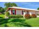 Beautifully landscaped front yard with red shutters and a white roof enhancing this home's curb appeal at 6701 12Th W Ave, Bradenton, FL 34209