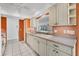 Well-lit kitchen with white cabinetry and a view into adjoining room creating an airy feel at 6701 12Th W Ave, Bradenton, FL 34209