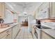Bright kitchen featuring white appliances, cabinets, and white tile floors overlooking the dining area at 6701 12Th W Ave, Bradenton, FL 34209