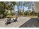 Expansive backyard with lush trees, a stone patio, and view of detached building at 6766 Beedla St, North Port, FL 34291