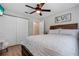 A comfortable bedroom featuring a ceiling fan, closet, ensuite access, and wood look tile at 6766 Beedla St, North Port, FL 34291