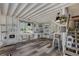 Bonus room with whitewashed walls and ceilings, gray plank floors, kitchenette, and staircase at 6766 Beedla St, North Port, FL 34291
