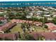 Aerial view showcasing condo community with manicured lawns, palm trees, shuffleboard, and a gazebo at 709 Sorrento Inlt # 709, Nokomis, FL 34275