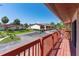 Balcony with red painted railing, overlooking beautiful green trees and a private neighborhood street at 709 Sorrento Inlt # 709, Nokomis, FL 34275
