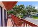 Balcony with red painted railing, overlooking beautiful green trees and a private neighborhood street at 709 Sorrento Inlt # 709, Nokomis, FL 34275