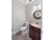 This half bathroom features stylish vanity with decorative mirror and wood-look flooring at 709 Sorrento Inlt # 709, Nokomis, FL 34275