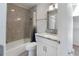 Bathroom featuring grey tiled shower, white vanity with granite countertop and framed mirror at 709 Sorrento Inlt # 709, Nokomis, FL 34275