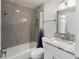 Bathroom featuring grey tiled shower, white vanity with granite countertop and framed mirror at 709 Sorrento Inlt # 709, Nokomis, FL 34275