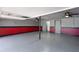 Large garage featuring epoxy flooring, red and gray painted walls, and lighting at 709 Sorrento Inlt # 709, Nokomis, FL 34275