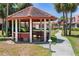 Outdoor gazebo with seating surrounded by lush greenery and walkway at 709 Sorrento Inlt # 709, Nokomis, FL 34275