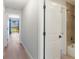 Bright hallway leading to bedrooms and living areas, with wood-look flooring throughout at 709 Sorrento Inlt # 709, Nokomis, FL 34275