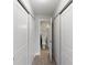 Hallway with closets and light wood floors leading to bathroom with white toilet, vanity and shower at 709 Sorrento Inlt # 709, Nokomis, FL 34275