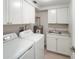 Bright laundry room featuring washer, dryer, sink, and ample cabinet space for storage at 709 Sorrento Inlt # 709, Nokomis, FL 34275