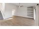 Open-concept living room with staircase, floating shelves, ceiling fan, and light wood flooring at 709 Sorrento Inlt # 709, Nokomis, FL 34275