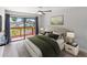 Bright bedroom featuring a ceiling fan, ensuite bathroom access, balcony, and neutral tones at 709 Sorrento Inlt # 709, Nokomis, FL 34275