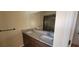 Bathroom with a dual sink vanity, a granite countertop, and a large mirror at 7102 52Nd E Dr, Bradenton, FL 34203