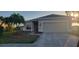 Inviting single-story home with a well-manicured lawn, mature palm tree, and a two-car garage at 7102 52Nd E Dr, Bradenton, FL 34203