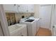 Bright laundry room with modern washer and dryer, cabinets, and utility sink at 7102 52Nd E Dr, Bradenton, FL 34203