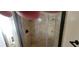 Modern walk-in shower featuring tiled walls, a glass door, and built-in shelving at 7102 52Nd E Dr, Bradenton, FL 34203