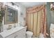 Unique bathroom features a white vanity, decorative mirror and floral shower curtain at 7118 Lakeside Dr # 7118, Sarasota, FL 34243