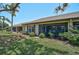 Back exterior shot of the home with lush landscaping and multiple screened-in lanais at 7118 Lakeside Dr # 7118, Sarasota, FL 34243