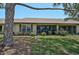 Back exterior view of the home highlighting the screened-in lanai and manicured lawn at 7118 Lakeside Dr # 7118, Sarasota, FL 34243