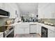 Well-lit kitchen with modern appliances, white cabinets, and an adjacent dining area at 7118 Lakeside Dr # 7118, Sarasota, FL 34243