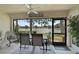 Screened-in lanai has table, chairs, ceiling fan and tranquil water view at 7118 Lakeside Dr # 7118, Sarasota, FL 34243