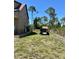 Side view of the backyard, featuring a lush green lawn, well-maintained landscaping, and functional outbuildings at 8412 Grove Blvd, Punta Gorda, FL 33982