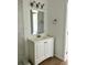 Bright bathroom featuring a vanity with a white cabinet, a framed mirror, and modern lighting fixtures at 8412 Grove Blvd, Punta Gorda, FL 33982