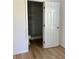Open doorway to a bathroom with marble shower, toilet, wood-look flooring, and white walls at 8412 Grove Blvd, Punta Gorda, FL 33982