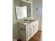 Bathroom vanity with white cabinets, drawers, countertop and a large mirror at 8412 Grove Blvd, Punta Gorda, FL 33982
