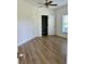 Bright bedroom features wood-look tile floors, ceiling fan, and an ensuite bathroom entrance at 8412 Grove Blvd, Punta Gorda, FL 33982