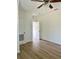 Open bedroom with ceiling fan, wood-look floors, white walls, and open closet doors at 8412 Grove Blvd, Punta Gorda, FL 33982