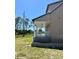 Side view of a home featuring a charming covered porch, lush green lawn, and meticulously maintained landscaping at 8412 Grove Blvd, Punta Gorda, FL 33982