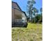 Side view of a home featuring a charming covered porch, lush green lawn, and meticulously maintained landscaping at 8412 Grove Blvd, Punta Gorda, FL 33982