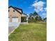 Side view of a charming two-story home featuring a two-car garage, a cozy porch, and a lush green lawn at 8412 Grove Blvd, Punta Gorda, FL 33982