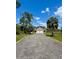 Charming two-story home with a well maintained gravel driveway and a two-car garage under a bright, sunny sky at 8412 Grove Blvd, Punta Gorda, FL 33982