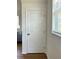 Hallway featuring a white door, window with blinds, and view of a kitchen at 8412 Grove Blvd, Punta Gorda, FL 33982