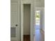 Hallway featuring white trim, doors, and walls, showcasing natural light and a glimpse of the outdoor view at 8412 Grove Blvd, Punta Gorda, FL 33982