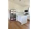 Bright kitchen featuring white cabinets, stainless steel appliances, an island, and hardwood flooring at 8412 Grove Blvd, Punta Gorda, FL 33982