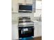 New Samsung stainless steel stove and microwave sit below white cabinets and counter in this renovated kitchen space at 8412 Grove Blvd, Punta Gorda, FL 33982